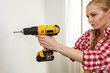 © Voyagerix - Woman using drill on wall