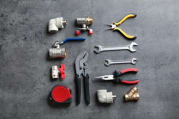 Flat lay composition with plumber's tools on grey background