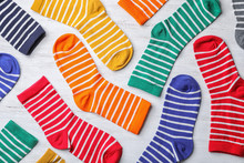 Flat Lay Composition With Cute Child Socks On White Wooden Background