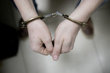 Fototapeta  - The arrested criminal handcuffed. Hands with handcuffs in the front