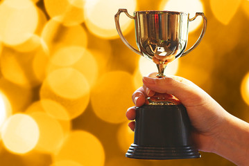 Wall Mural - winner hold trophy with background abstract night bokeh light