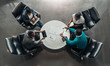 © JonoErasmus - Group of African business people sitting and discussing statistics during a sit down meeting taking from above