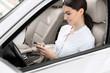 © Prostock-studio - Business woman sitting in car, using mobile phone
