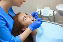 Doctor In Uniform Checking Up Female Patient's Teeth In Dental Clinic