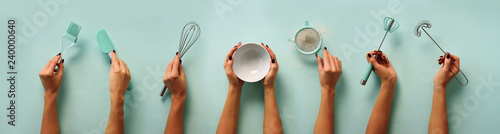 Female hands holding kitchen tools, sieve, rolling pin, bowl, sieve, brush, whisk, spatula for baking and cooking over pastel blue background Poster Mural XXL