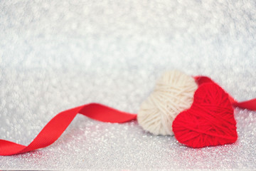 Valentines Day background, mockup with two red knitted fluffy heart on silver shiny glitter background. Valentine Day, love, romance, dating concept, copy space