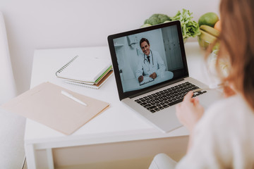 Lady speaking with doc online on pc laptop