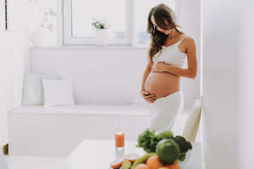 Wall Mural - Excited glad woman holding hands on stomach