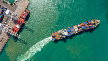 Container ship in export and import business logistics and transportation. Cargo and container box shipping to harbor by crane. Water transport International. Aerial view and top view.