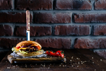 Wall Mural - delicious burger with a knife stuck in a bar