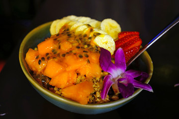 Wall Mural - Acai bowl with granola, banana and fresh berries decorated with an orchid flower