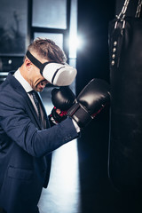 Wall Mural - businessman in suit and virtual reality headset boxing and screaming in gym