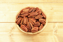 Pecan Nuts In Bamboo Bowl On Wooden Table