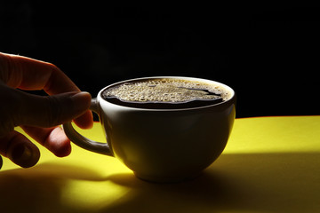 Hot coffee on yellow background