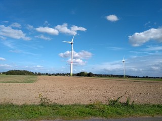 Electric turbine windmill with fairy tale landscape and cloudscape