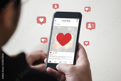 Cuadros en Lienzo Man holding smartphone using mobile application for instagram on the screen