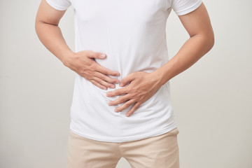 people, healthcare and health problem concept - unhappy man suffering from stomach ache over white background