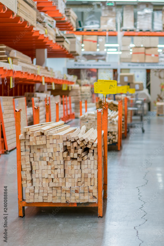 stack new wooden bars on shelves inside lumber yard of large hardware ...