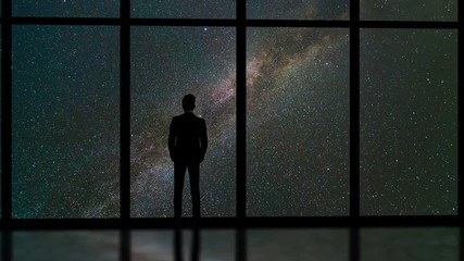 Wall Mural - The man standing near window on a stars background. time lapse