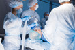 © alfa27 - Anesthetists in uniform and masks working together in a surgical room, Team of surgeon prepare to operation on a patient at cardiac surgery clinic.