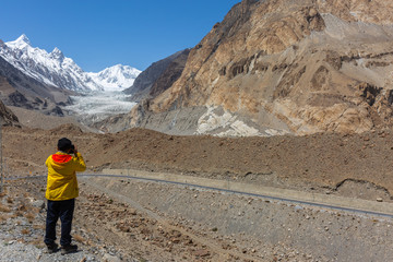 Wall Mural - Photographer take photo at Passu Glacier. Karakorum region. Passu Peak is situated in the back side of the glacier.Northern Pakistan.