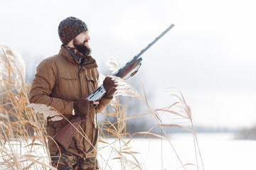 Wall Mural - careful hunter with a license. close up photo. copy space. man is looking for a deer for shooting