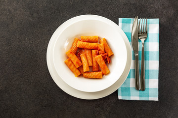 Penne Amatriciana fresh pasta with parmesan cheese on dark backg