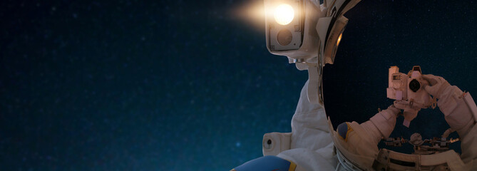 Wall Mural - astronaut in outer space takes a selfie on the camera. spaceman travels in space against the backgro