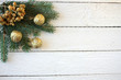 Bożonarodzeniowe tło, białe deski, złota jarzębina, pozłacane orzechy włoskie i gałązki świerku