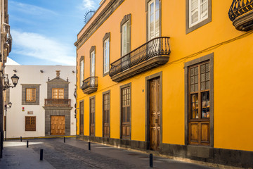 Street view of Las Palmas Town on Gran Canaria , Canary Island, Spain. Facades of orange and white old houses with brown wooden windows and doors and a balcony