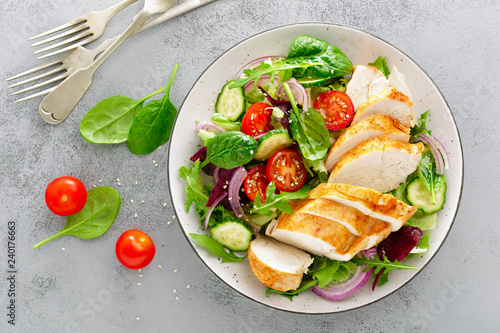 Cuadros en Lienzo Grilled chicken breast, fillet and fresh vegetable salad of lettuce, arugula, spinach, cucumber and tomato