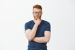 © Cookie Studio - Creative and smart businessman thinking about new concept for business. Portrait of handsome strategist with red hair and bristle, holding hand on beard and staring at camera focused