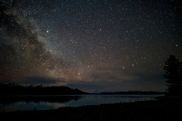 beautiful milky way, starry night over the snow mountain at lake pukaki, new zealand. high iso photo