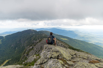 a hiker enjoys the great views atop the highest mountain in Vermont