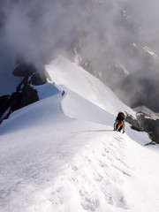 Poster - mountain climbers on a steep and narrow snow ridge leading to a high peak in the Swiss Alps