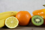 Fototapeta Kuchnia - Zdrowa dieta - owoce i warzywa - pomarańcze, kwi, cytryna i banan na drewnianej skrzynce