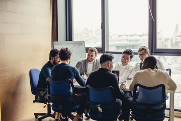 Canvas Print - Weekly Meeting of all our sales division multiracial staff in the conference room. Group of business people having discussion in boardroom. Creative business team brainstorming over new project.