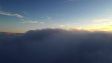 Wall Mural - aerial flight above clouds during golden hour in sunrise light.