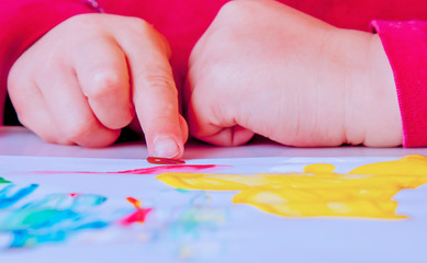 Art, creativity, beauty childhood concept. Little cute child girl painting with inger.