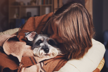 pretty young owner cuddling with her cute dog