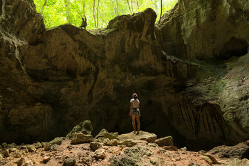 Young woman explorer observing ancient caribbean cave. Los Haitises natonal park in Dominican Republic.