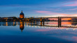 Sunset over Garonne River, with reflections of Saint-Pierre Bridge and Chapel of hôpital Saint-Joseph de la Grave, in Toulouse, France