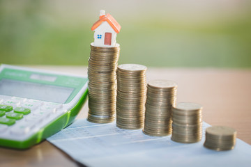 Mini house on stack of coins,Money and house,  Mortgage, Savings money for buy house and loan to business investment for real estate concept. Invesment and Risk Management, isolated.