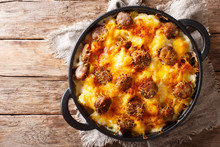 Delicious Potato Casserole, Sausages With Cheese Sauce Close-up In A Frying Pan. Horizontal Top View