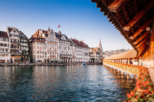 Lucerne Chapel Bridge And Old Buildings In Bright Evening, Switzerland