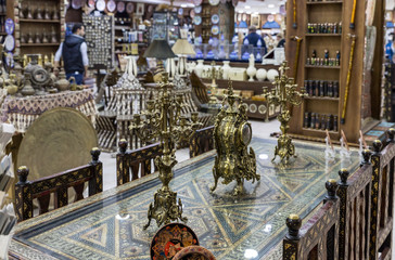 Decorative clocks and candlesticks stand on a decoratively decorated dining table in a roadside store near Kerak city in Jordan