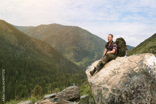Foto A tourist on a high mountain looks at nature