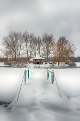 Wall Mural - The winter landscape with forest, lake in the bad weather condition