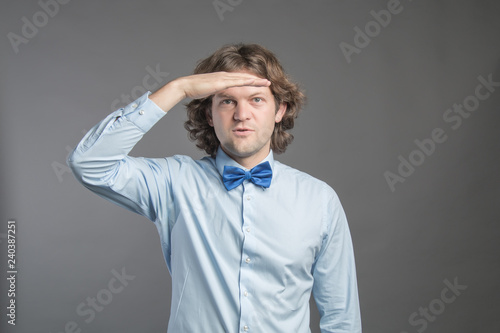 Handsome Young Man With Dark Curly Hair Wearing Blue Shirt And Bow