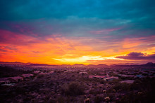 A Colorful Sunset Over A Neighborhood In The Desert Of The American Southwest. The Sky Has Warm Golden Colors On The Horizon With Cool Blue Tones In The Clouds At The Top Of The Image.